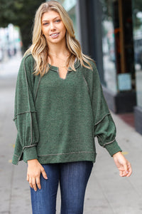 The Slouchy Two Tone Knit Notched Raglan Top in Olive